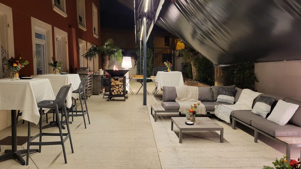 La terrasse un soir de réception : mange-debout, brasero et salon