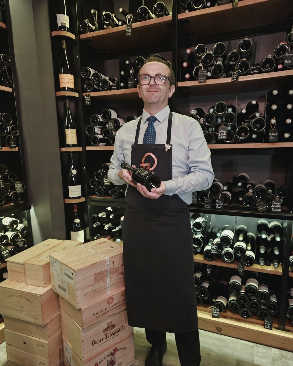 Fabrice Vial, notre sommelier, dans la cave, une bouteille à la main